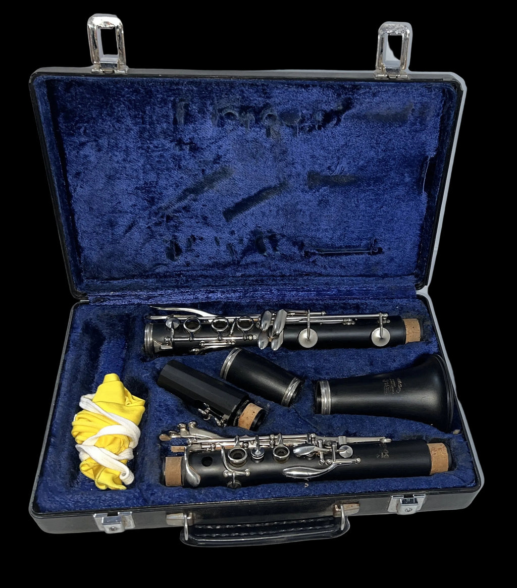 Clarinet set with case, mouthpiece, and cleaning rod on a white surface